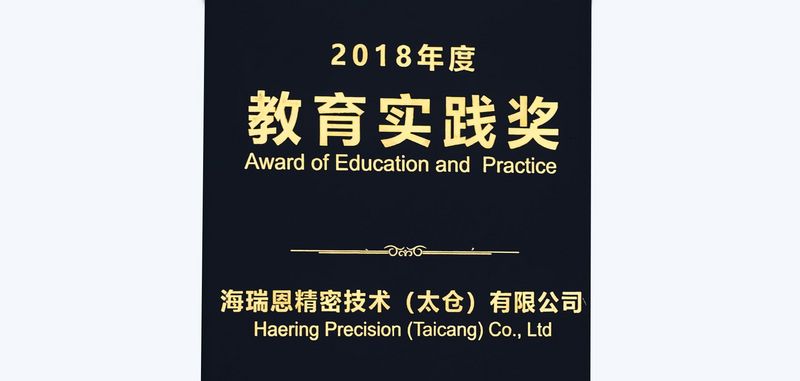 Schwarzes DINA 4 Blatt mit goldener Schrift "Award of Education and Practice - Häring Precision (Taicang) Co., Ltd - Taicang High-tech Industrial Development Zone"